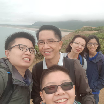 Malaysian family smiling on the coast of Gower