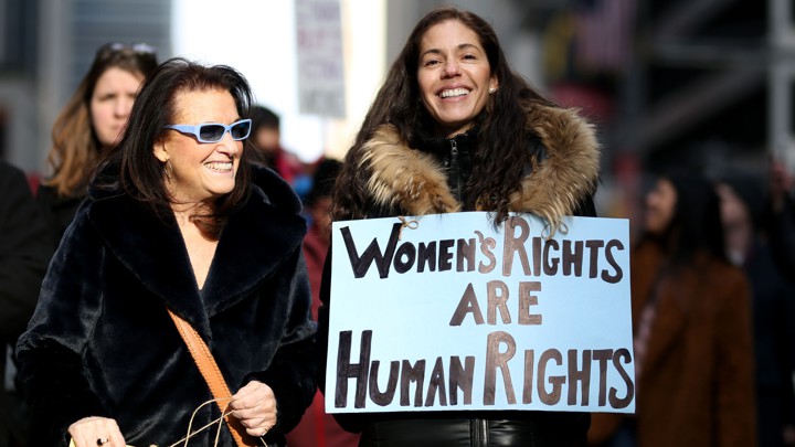 Two people campaigning on how women's rights are human rights