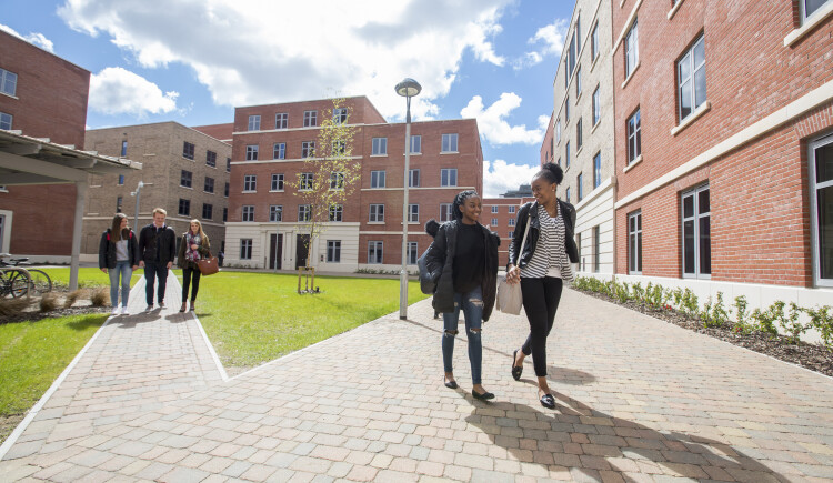 Two students walking between accommodation block.