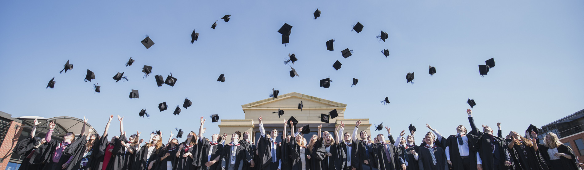 Students throwing their caps in the air at Graduation
