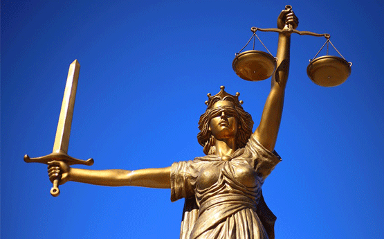 Statue of Lady Justice against a brilliant blue sky