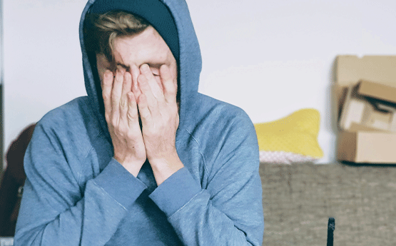 A person with their hands in their head looking stressed.