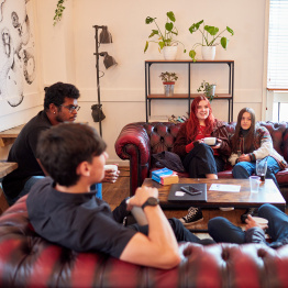 A group of students talking in JC's social space in Fulton House on Singleton Campus. 