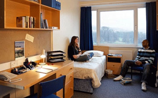 two students chatting in a bedroom