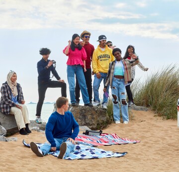 A group of students posing for a photo on the beach
