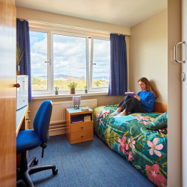 An image of a student in a bedroom in student accommodation on Singleton Campus.