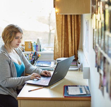 a female student at a laptop in residences