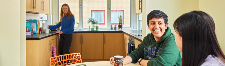 An image of three students talking in a kitchen in student accommodation.