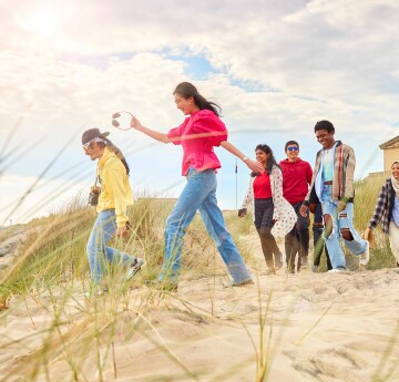 Students walking along the beech at Swansea Bay