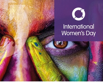 Close image of left eye of a woman's face painted in various colours with International Women's Day logo 