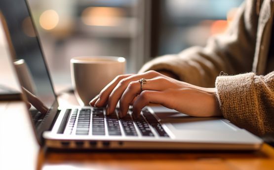 Hands typing on laptop