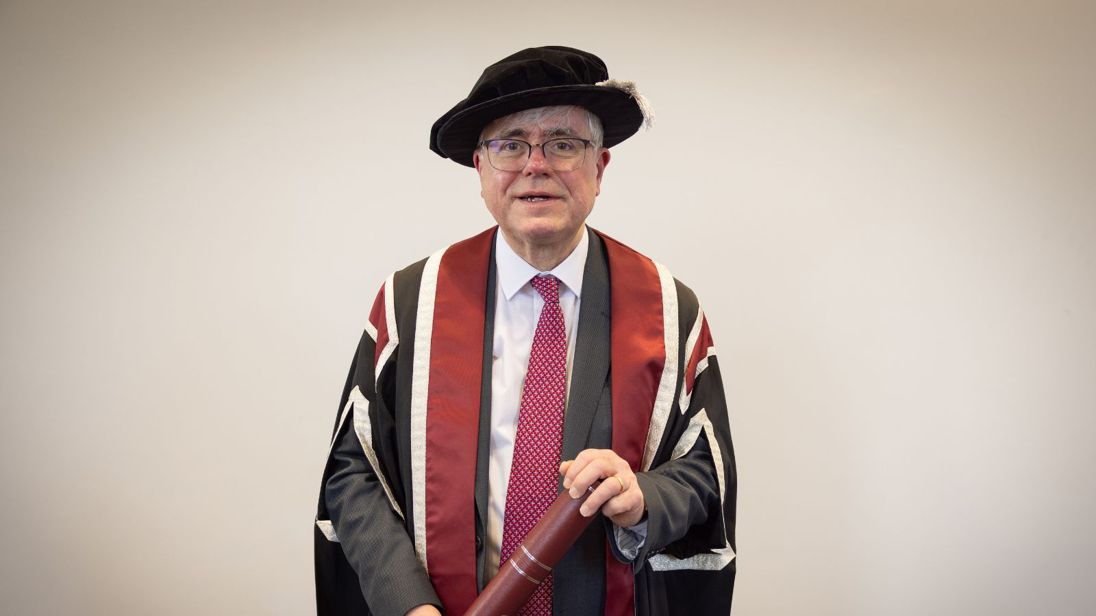 Man wearing cap & gown smiling for the camera