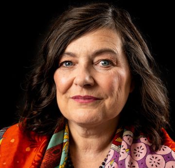 Woman smiling against a black background