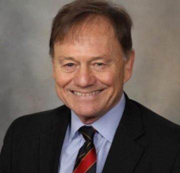 Man in shirt & tie smiling at the camera