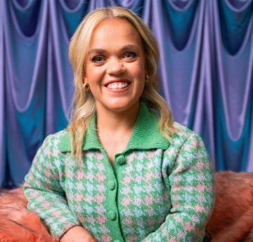 Lady in a green jacket smiling at the camera