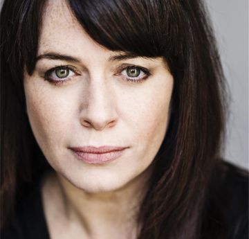 Headshot of a lady with dark hair looking at the camera