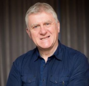 Man in navy shirt smiling at the camera