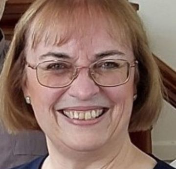 Lady with glasses smiling at the camera