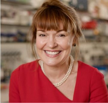 Lady in smart clothing looking at a camera and smiling