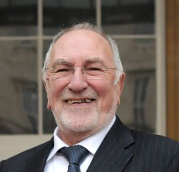 Man in shirt and tie smiling at the camera