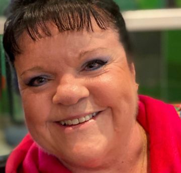 Woman with dark hair looking directly at the camera