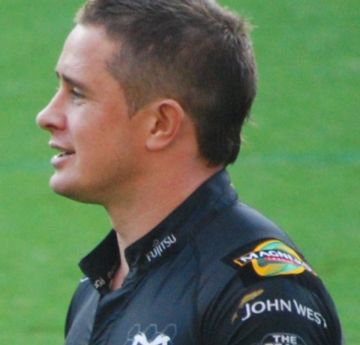 Man playing on a rugby field with a black jersey