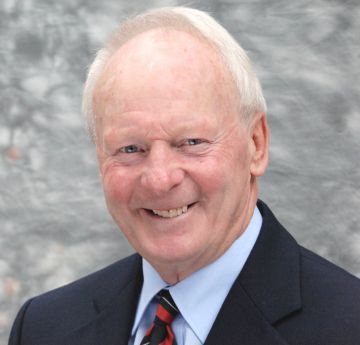 Man wearing a shirt and tie smiling at the camera