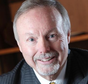 Man in a suit & tie smiling at the camera