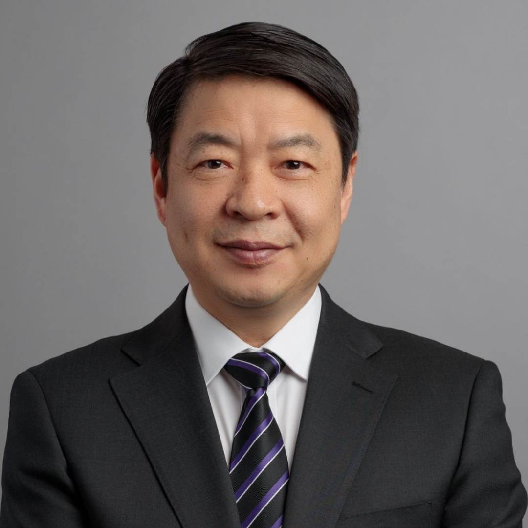 Man wearing a shirt & tie smiling at the camera