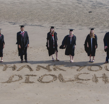 graduates on the beach