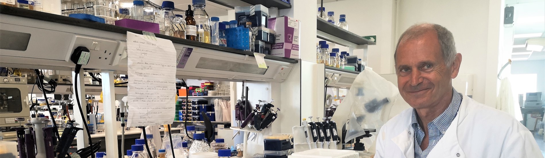 Professor Paul Dyson at work in the lab, surrounded by papers and equipment. 