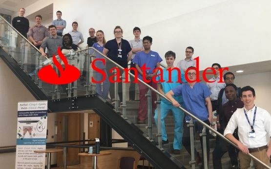 santander logo over Swansea medical students lined up on the stairs
