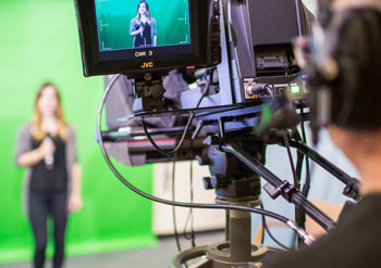 Student being filmed in front of a green screen