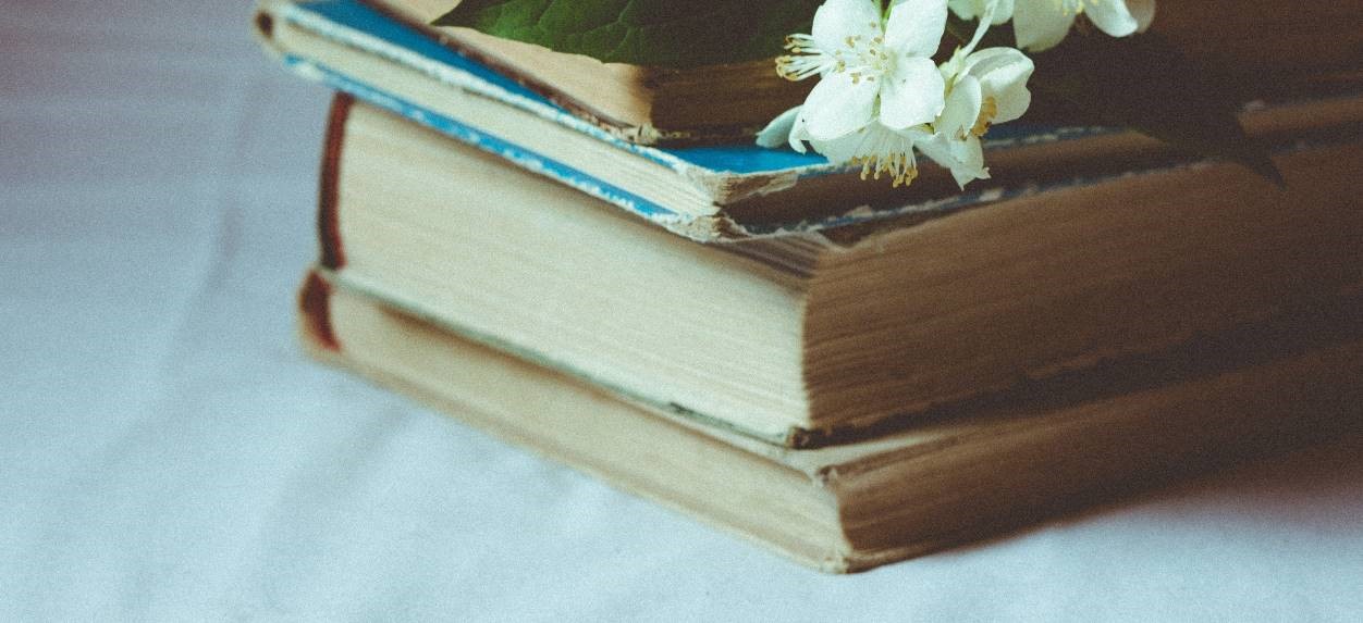 Old books and a white flower. 