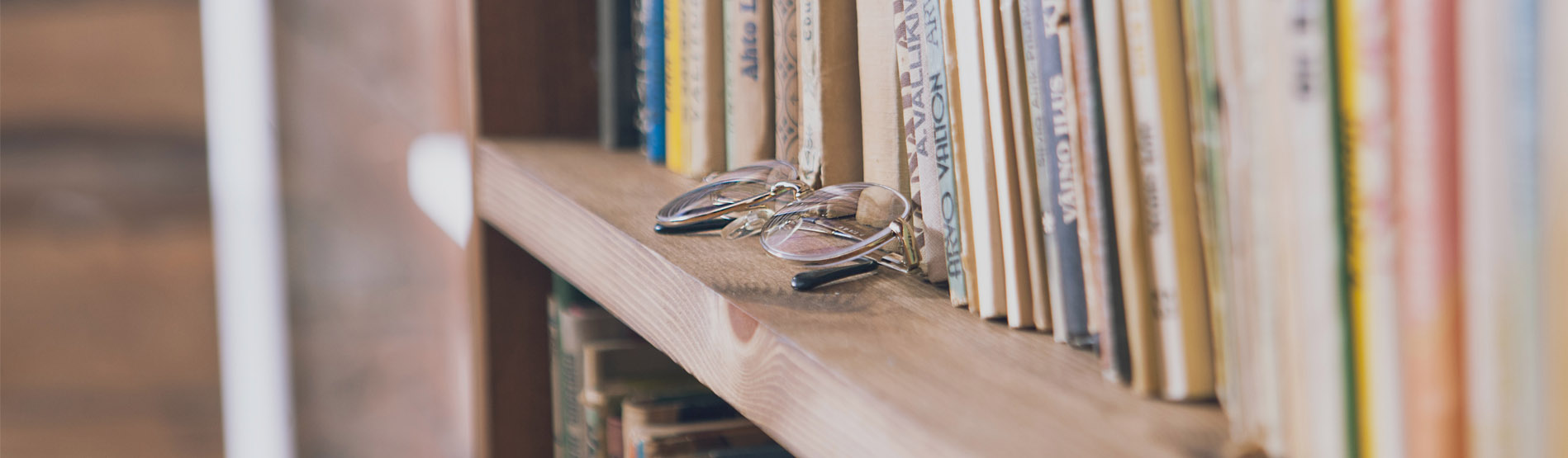 Image of book shelf with books and glasses 