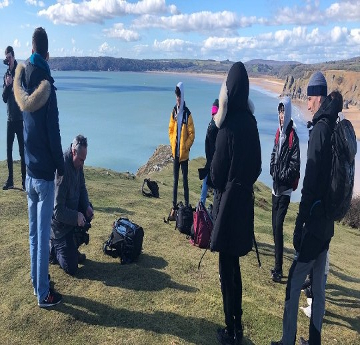 Image of a film crew on the cliffs filming a documentary about Gower. 