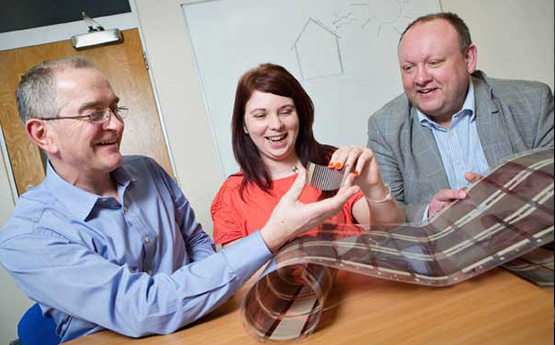 Three people looking at a new material created through research and development