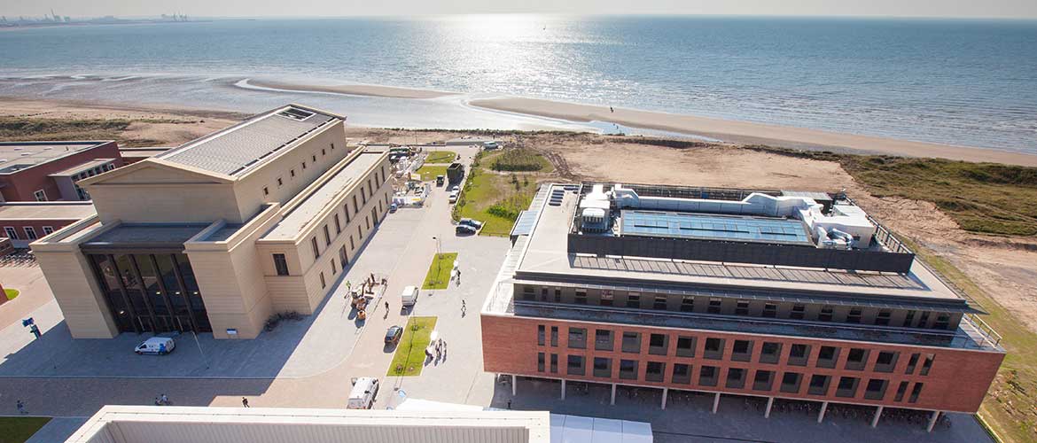 Arial view of Swansea University Bay Campus with the sun shining, overlooking the beachfront 