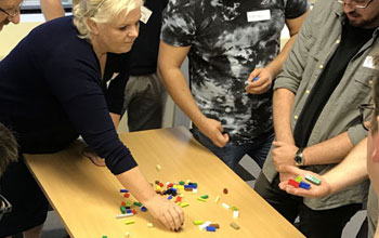 Woman moving coloured blocks on a table as part of a training exercise