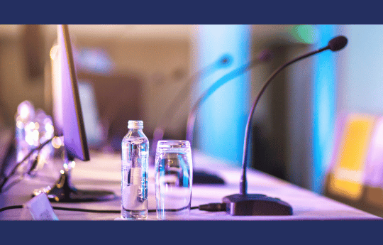 Desk microphones and bottle of water with glass