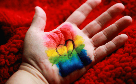 Hand with rainbow and heart on.