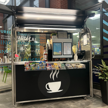 A small coffee cart with chocolate bars displayed