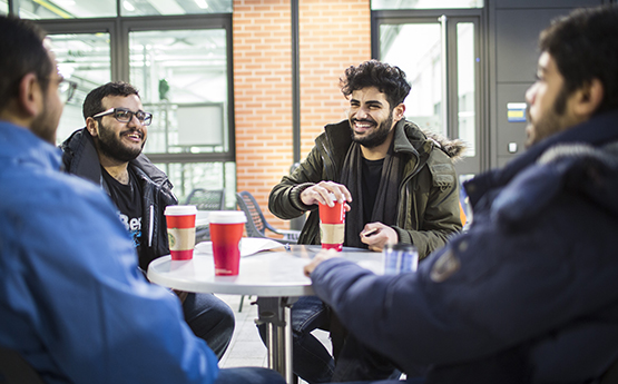 Students drinking coffee around a table