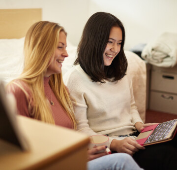 2 students looking at a laptop in a halls of residence