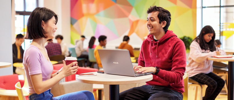An image of two students talking in a social space on the Bay Campus.