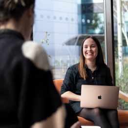 An image of a student talking with another student with a laptop in Taliesin Create on Singleton Campus. 