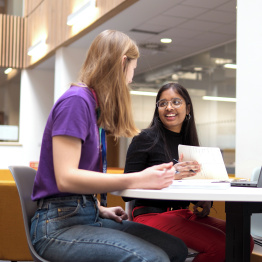 An image of two students talking to each other. 