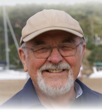 Bryn Griffiths wearing a baseball cap in front of sailing boats