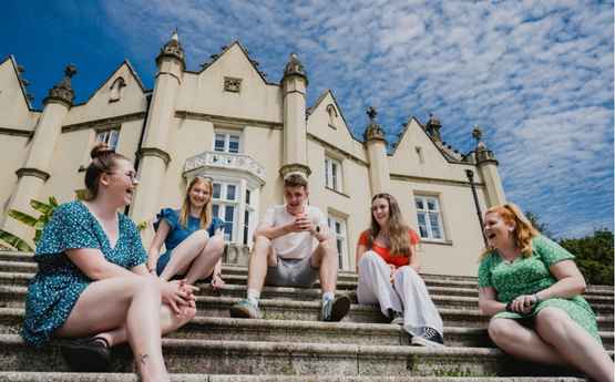 Myfyrwyr yn eistedd tu allan i Abaty Singleton 