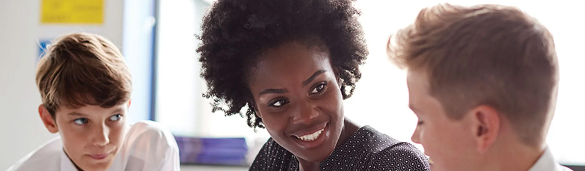 Athro yn siarad â dau ddisgybl